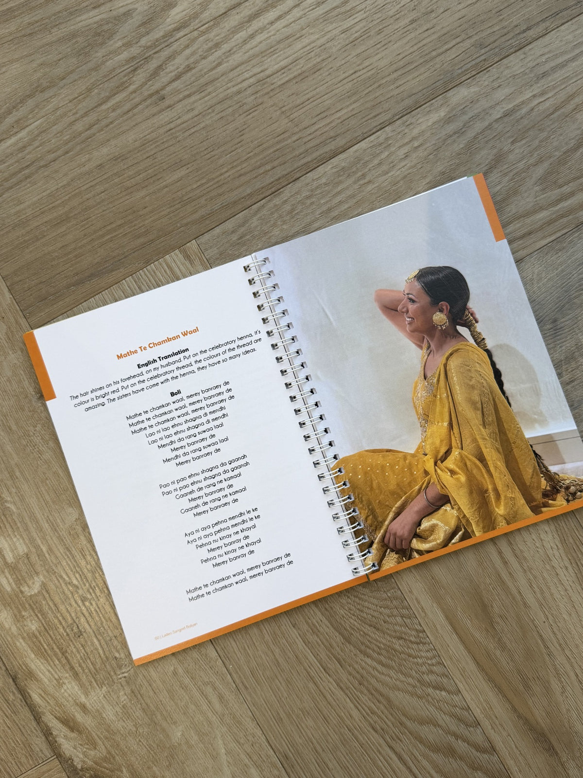 Inside the Ladies Sangeet Boliyan book showing Punjabi wedding songs, English translations and traditional boliyan.